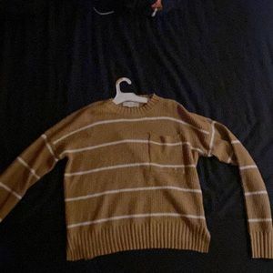 This is a cozy yellow sweater with white lines and a front pocket.
